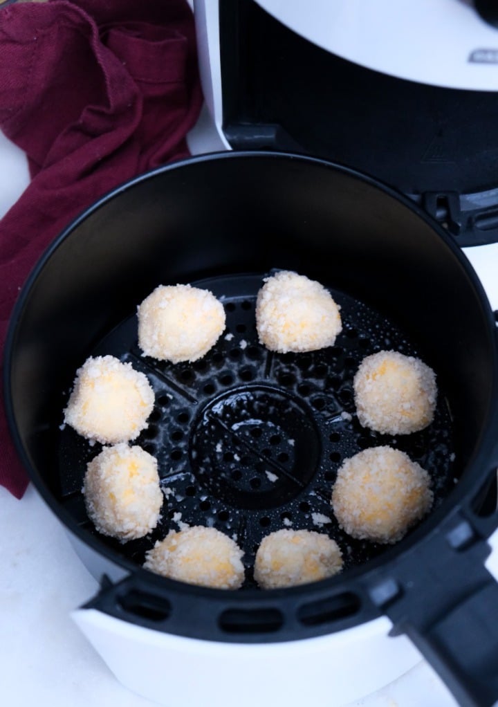 Potato bites in an air fryer getting ready to cook.