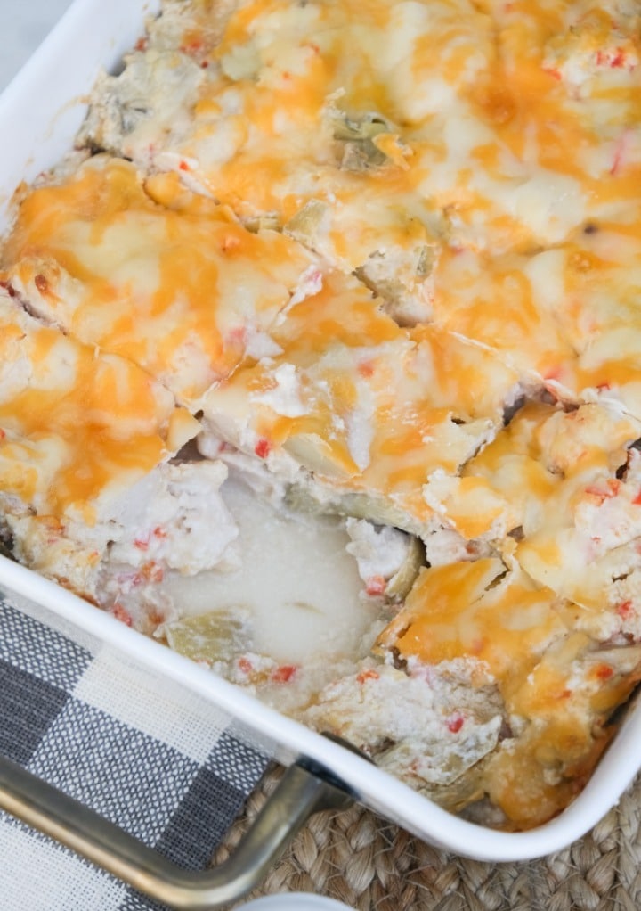 Casserole meal with melted cheese with a slice out of the dish. 