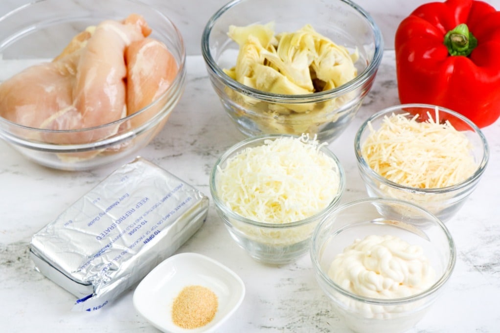 Ingredients to make a casserole dish with chicken and artichokes. 