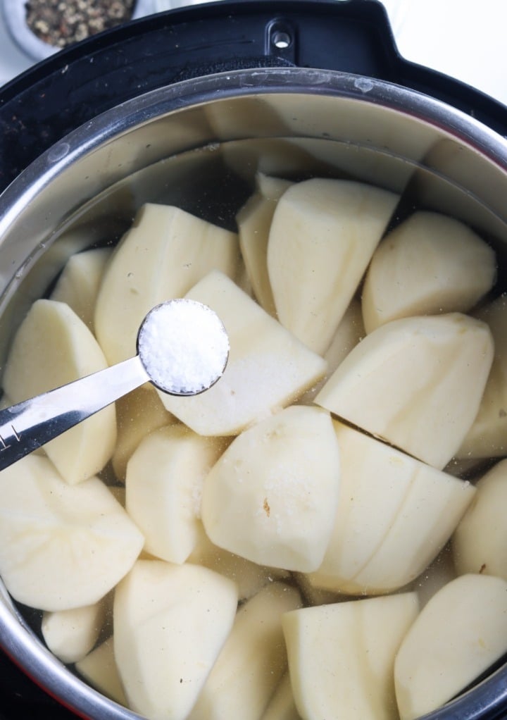 Adding a teaspoon of salt to diced potatoes in an Instant Pot before cooking. 