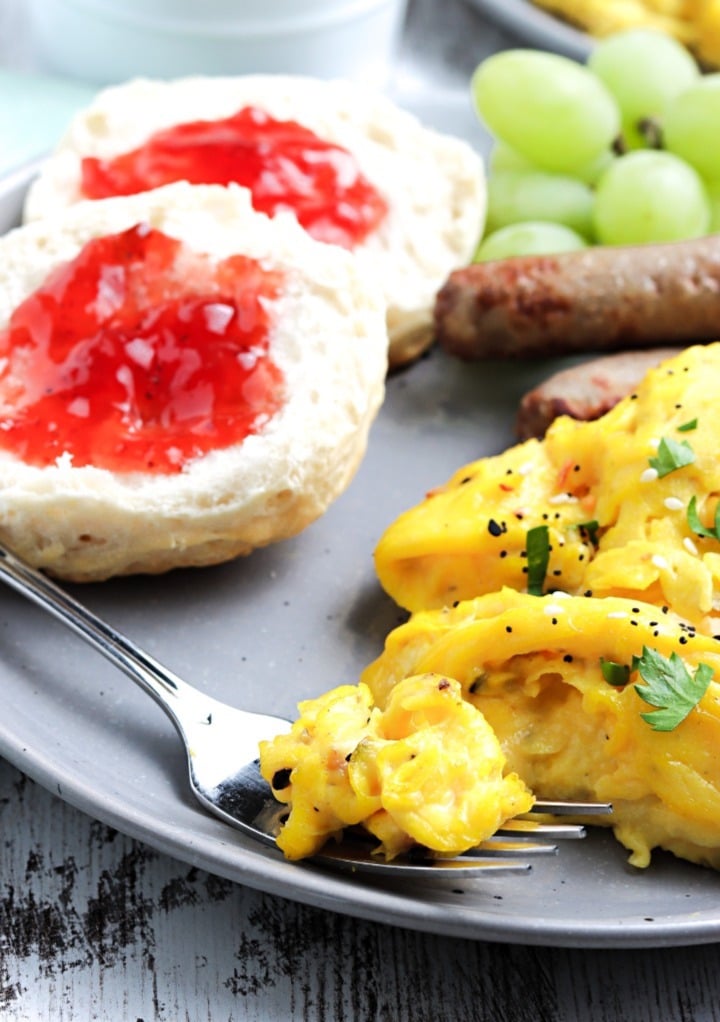 A forkful of healthy scrambled eggs topped with diced cilantro ready to eat. 