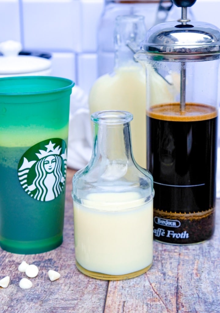 Coffee press filled with fresh coffee and a Starbucks glass ready to make a white chocolate mocha beverage. 