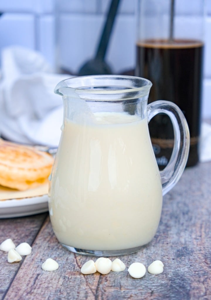 A small glass pitcher with homemade white chocolate syrup ready to use. 