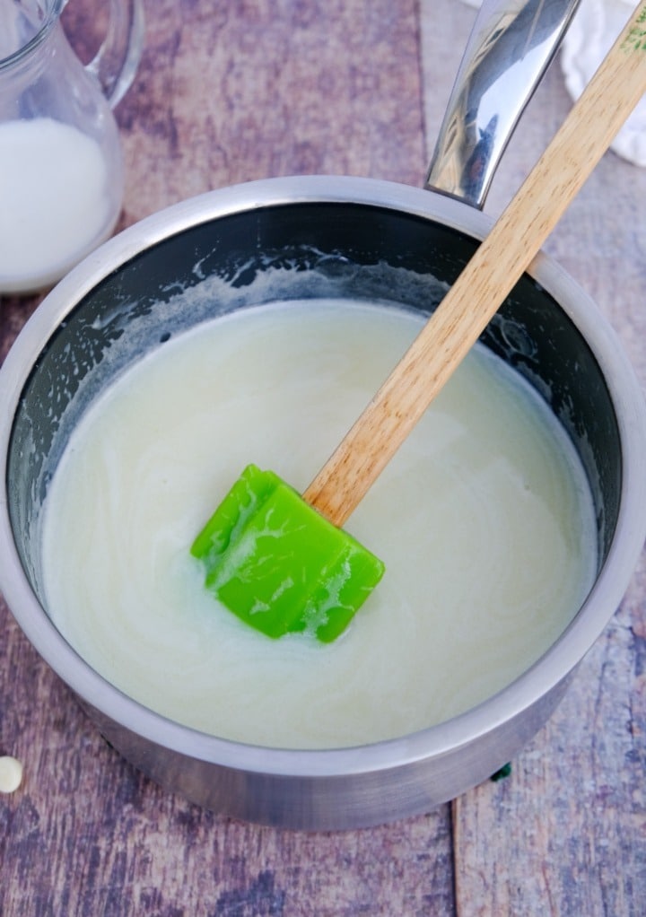 Creamy white chocolate syrup in a sauce pan cooling . 