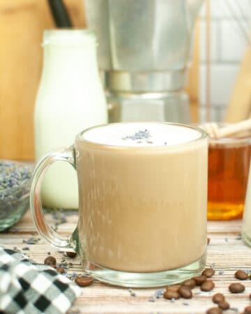 Hot coffee in a clear mug infused with lavender syrup.