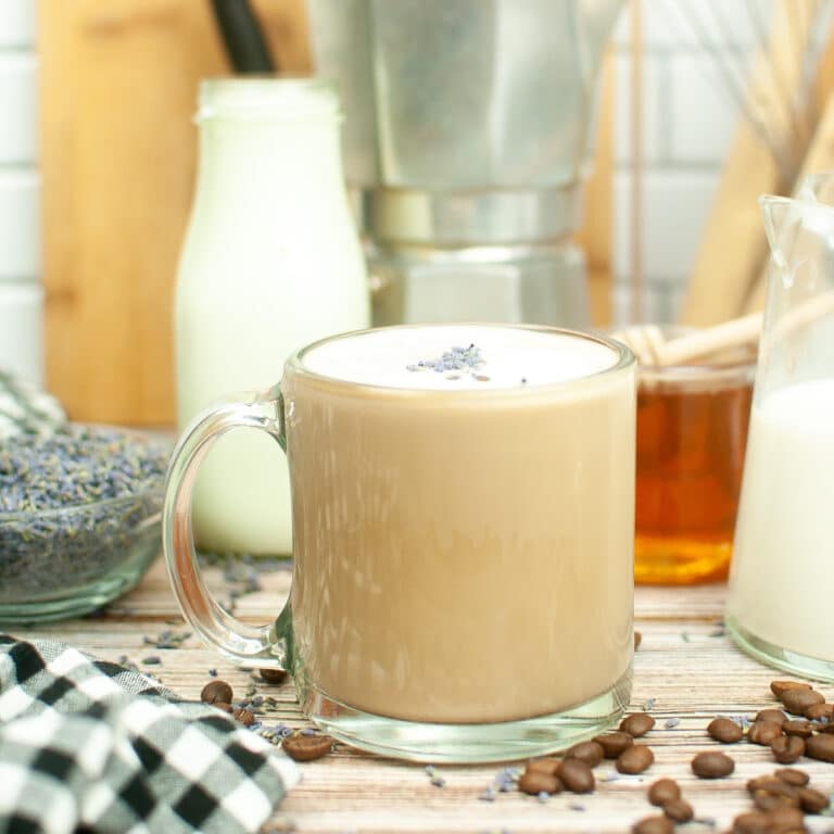 Hot coffee in a clear mug infused with lavender syrup.