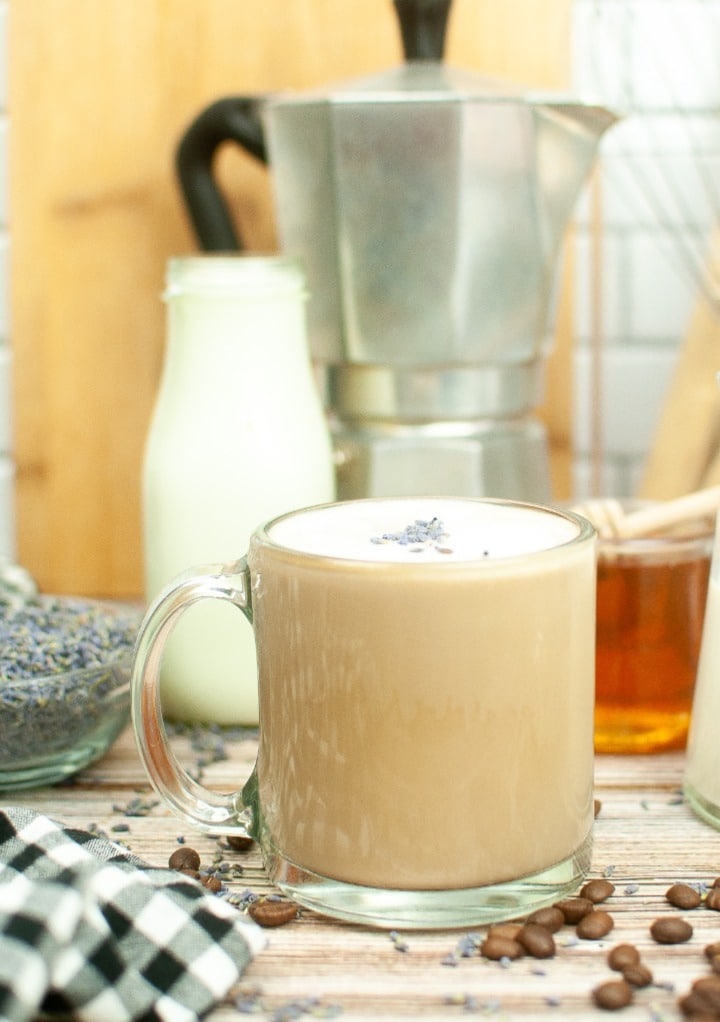 Mug of coffee with an expresso pot in the background. 