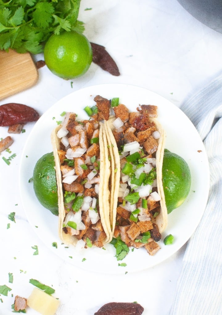 Top view of two tacos on a white plate. 