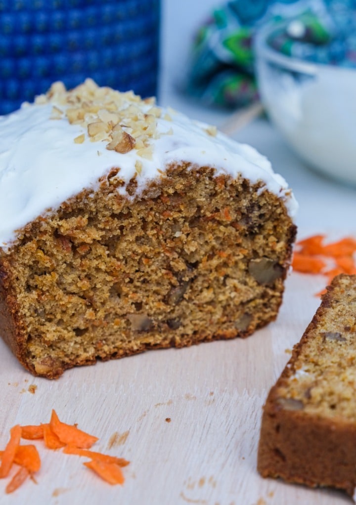 Quick bread with carrots on a cutting board with fresh shredded carrots. 