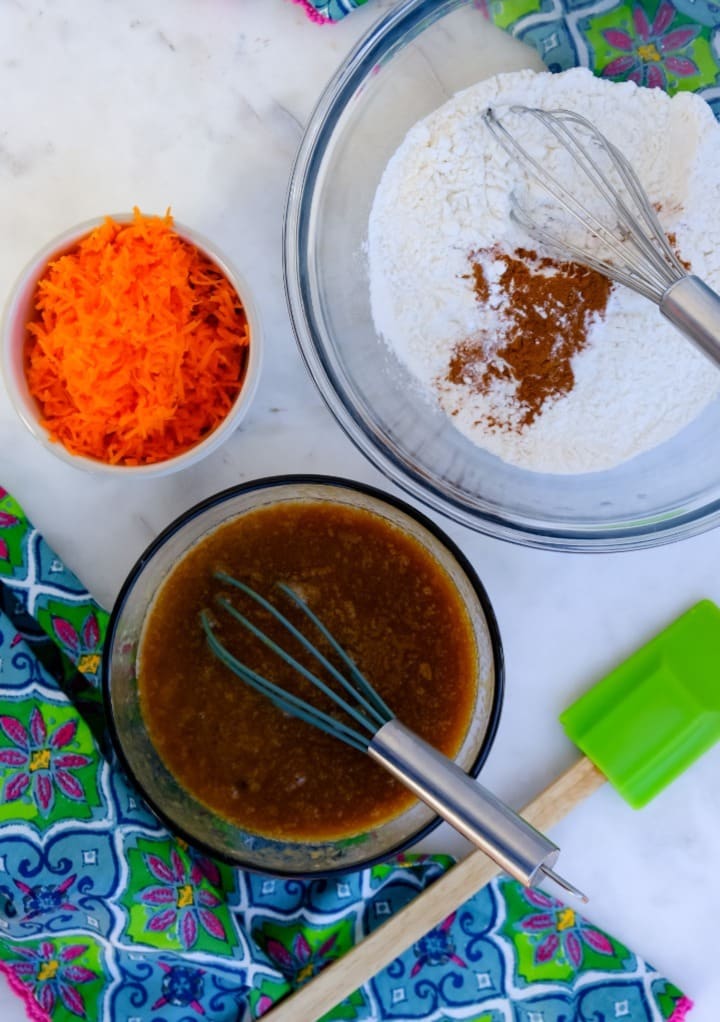 Dry and wet ingredients in mixing bowls to make carrot cake loaf. 