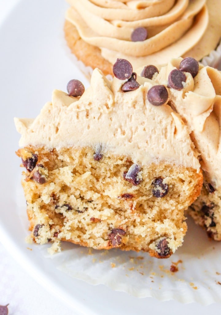 Peanut butter cupcake sliced in half exposing the center with chocolate chips. 