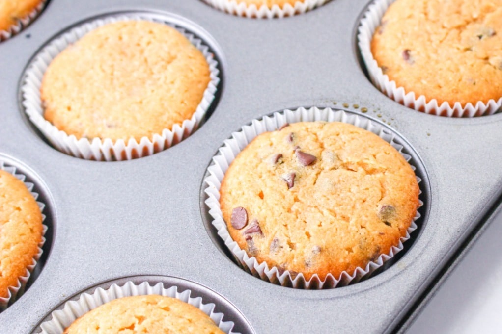 Baked peanut butter cupcakes in a muffin tin before placing on a cooling rack. 