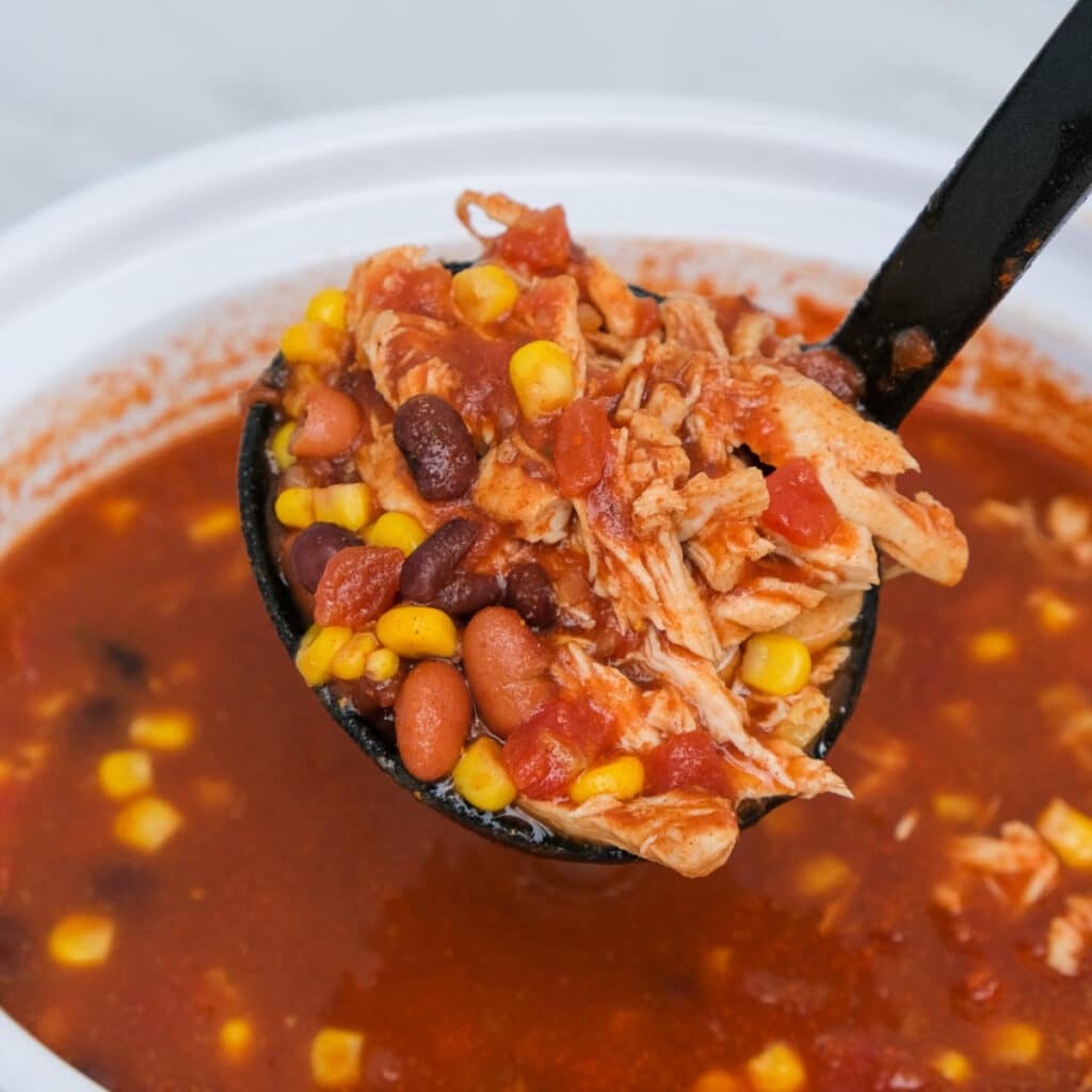 A black ladle with a scoop of slow Cooker Chicken Taco Soup.