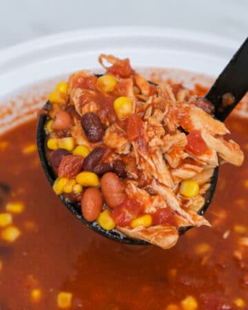A black ladle with a scoop of slow Cooker Chicken Taco Soup.