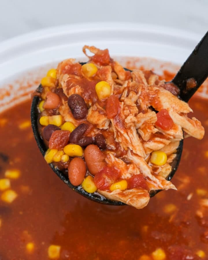 A black ladle with a scoop of slow Cooker Chicken Taco Soup.
