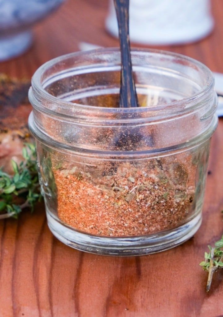 Homemade easy steak seasoning recipe with spices and herbs mixed and put in a small mason jar with a wooden spoon.