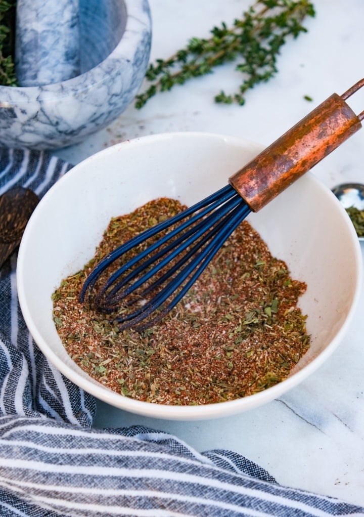 Homemade steak seasoning whisked together in a small white mixing bowl ready to use. 