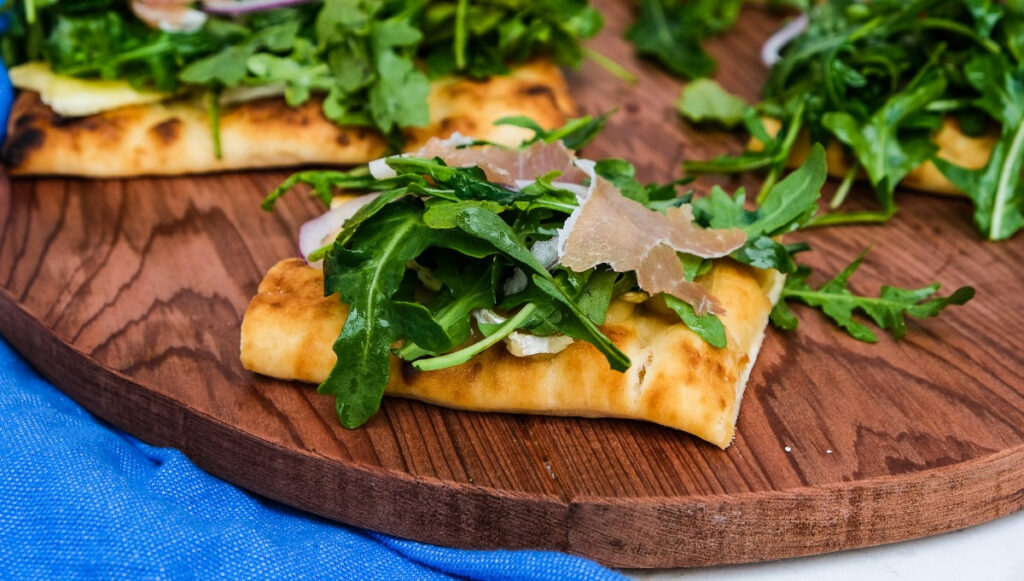 Pizza crust topped with arugula.