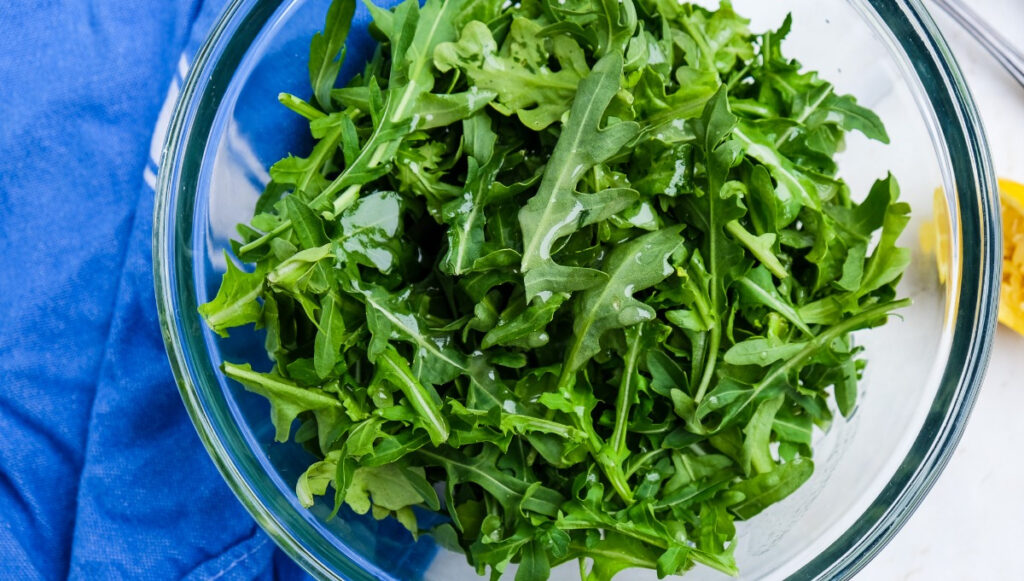 Arugula tossed with olive oil and lemon dressing. 