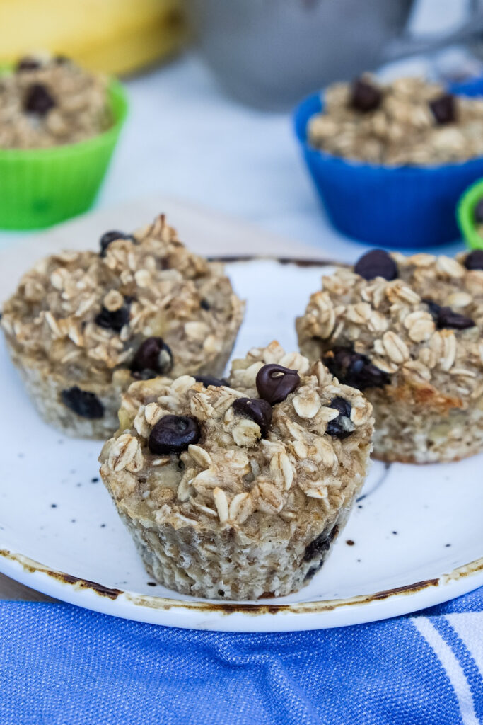 Oatmeal muffins with chocolate chips on a white serving plate. 