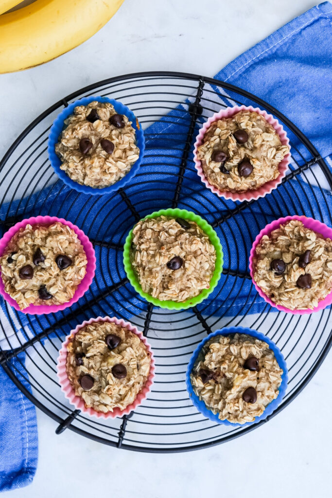 Overhead view of oatmeal muffins cooling on a round baking rack. 