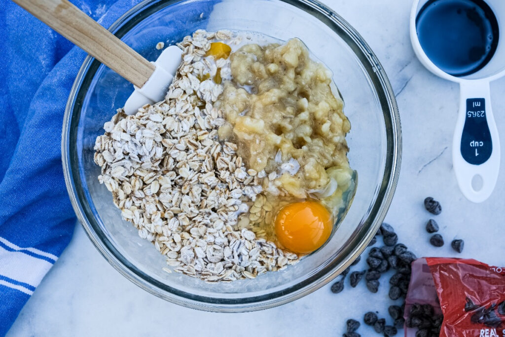 Large mixing bowl with ingredients to make oatmeal cups. 