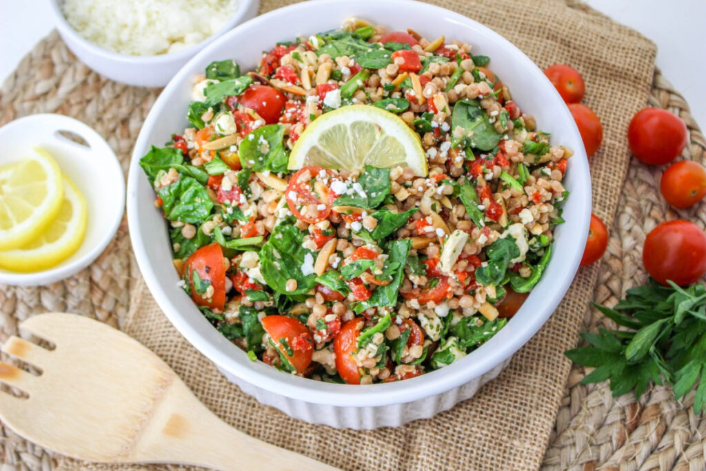 Pearl couscous salad in a white serving bowl. 