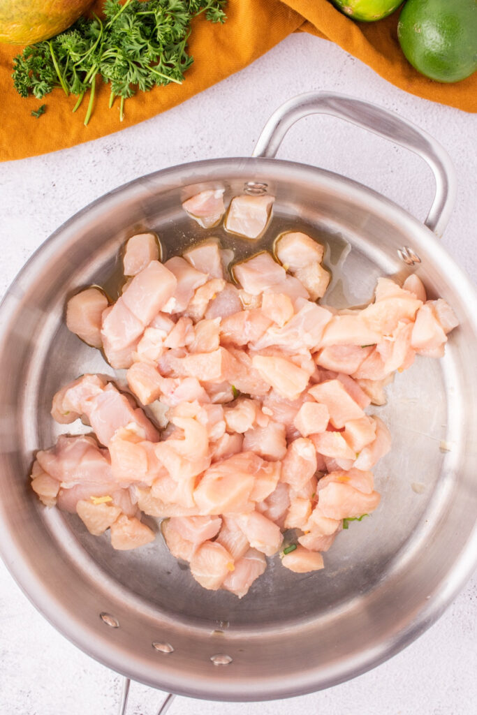 Diced chicken in a skillet before cooking. 