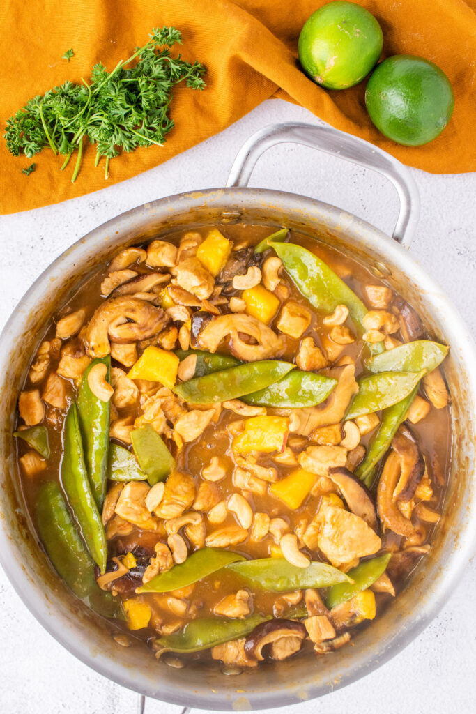 Cooked Thai coconut lime chicken recipe in a large silver skillet. 