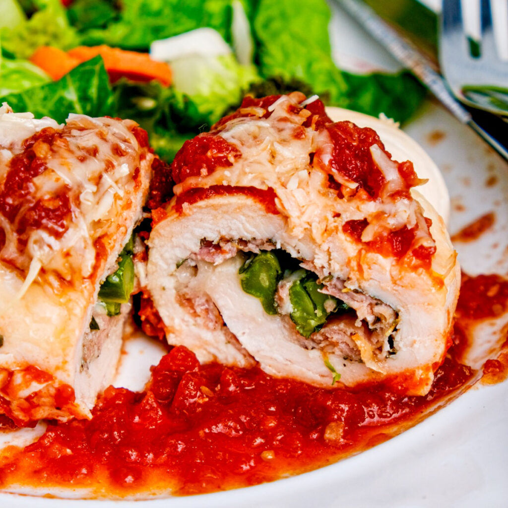 Chicken Rollatini with broccolini and prosciutto with marinara sauce.