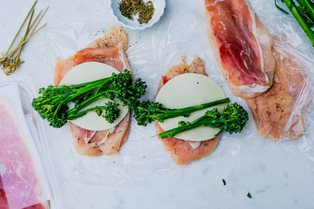 Sliced broccoli over a slice of cheese before rolling and cooking chicken. 