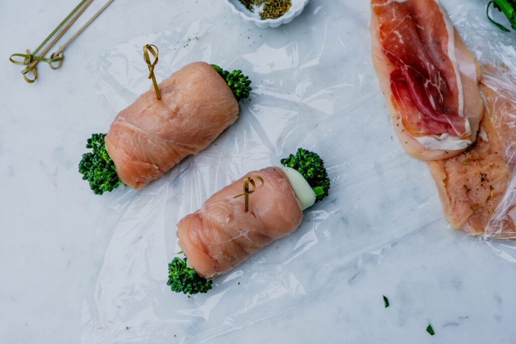 Rolled chicken breasts stuffed with cheese and broccoli before cooking. 