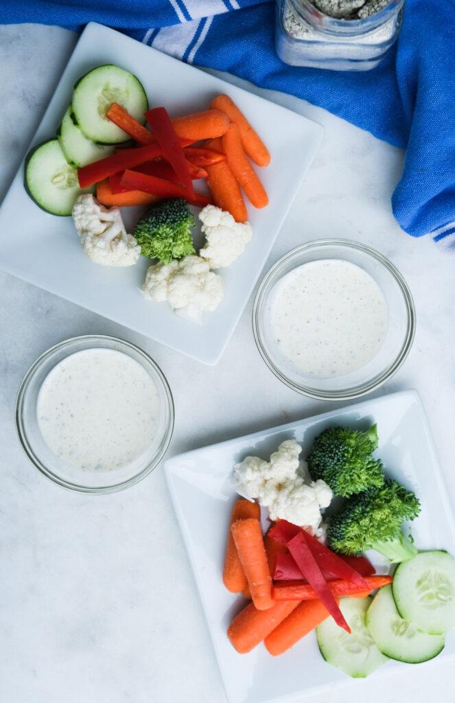 Overhead view of small plates of raw vegetable with Keto ranch dressing. 