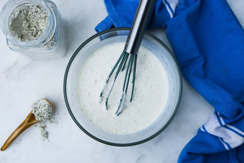 Whisked ingredients for ranch dressing in a small mixing bowl.