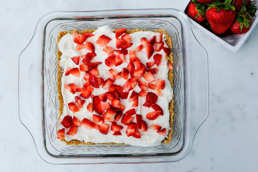 The first layer of strawberries over cream cheese icebox cake. 