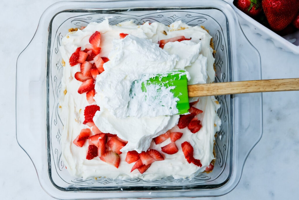 Fresh whipped cream over strawberry icebox cake. 