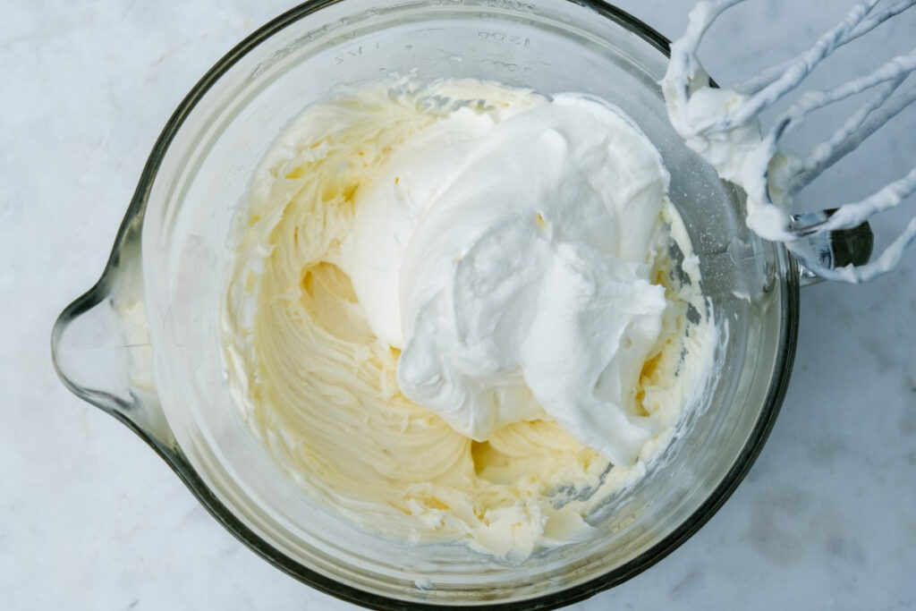 Folding in fresh whipped cream into cream cheese mix. 