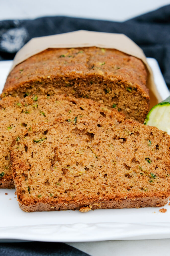 Sliced homemade zucchini bread on a white serving plate. 
