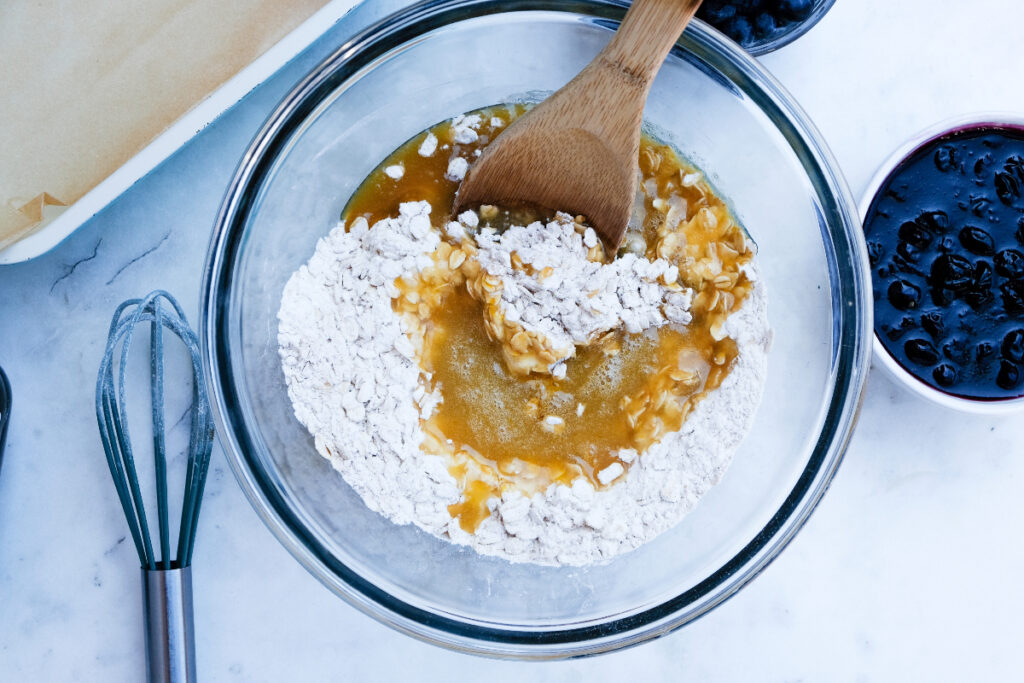 Wet and dry ingredients in a clear mixing bowl before mixing together. 
