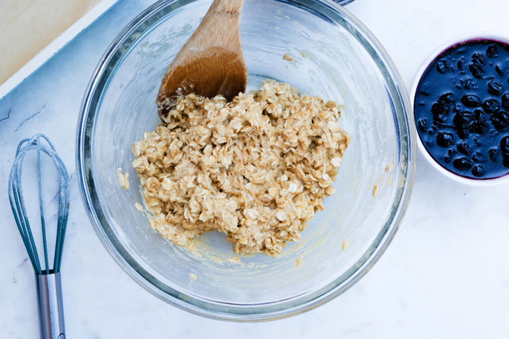 Bar oatmeal dough mixed in a clear mixing bowl. 