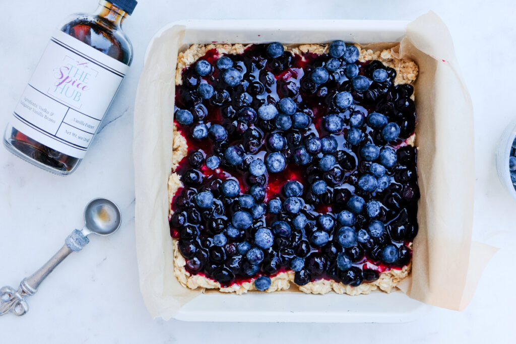 Fresh blueberries over blueberry sauce before baking in the oven.