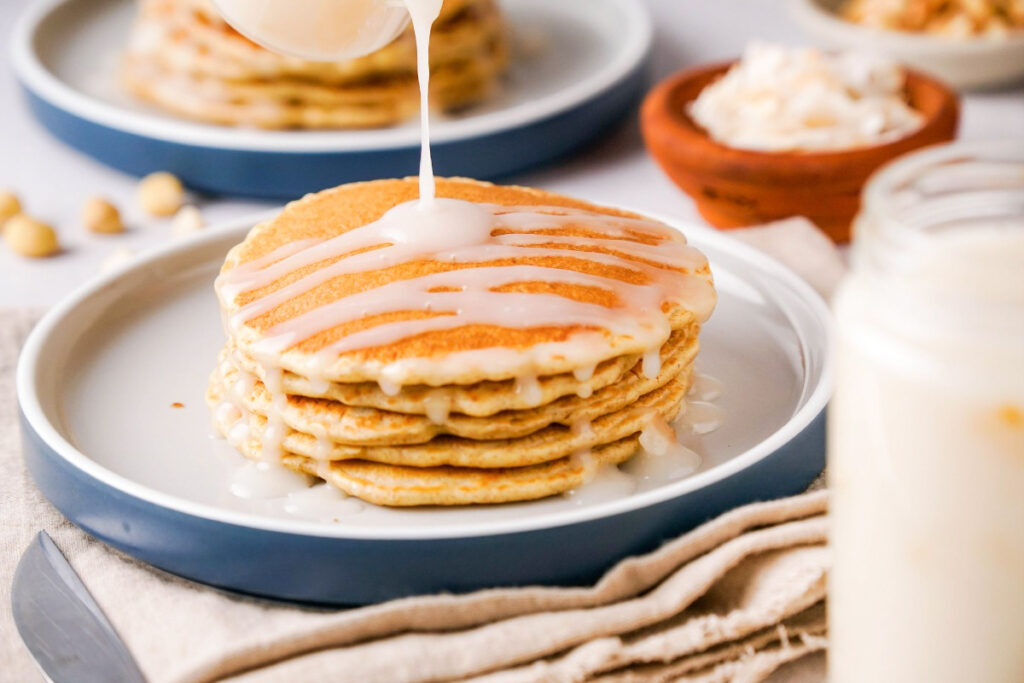 A stack on pancakes on a blue rimmed plate. 
