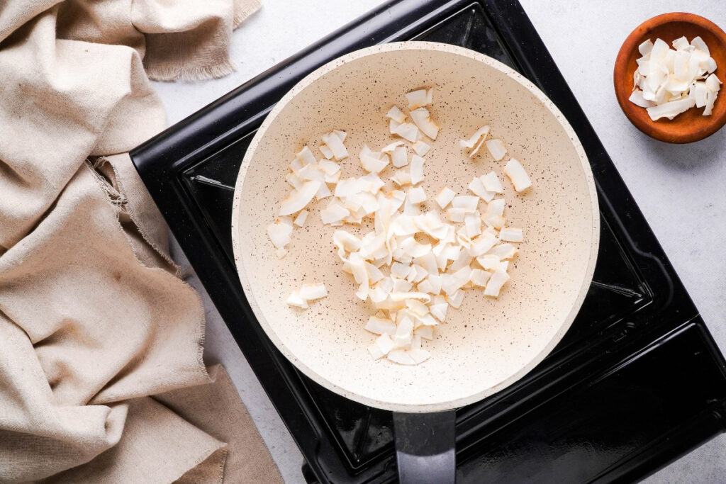 toasting coconut flakes in a saucepan. 