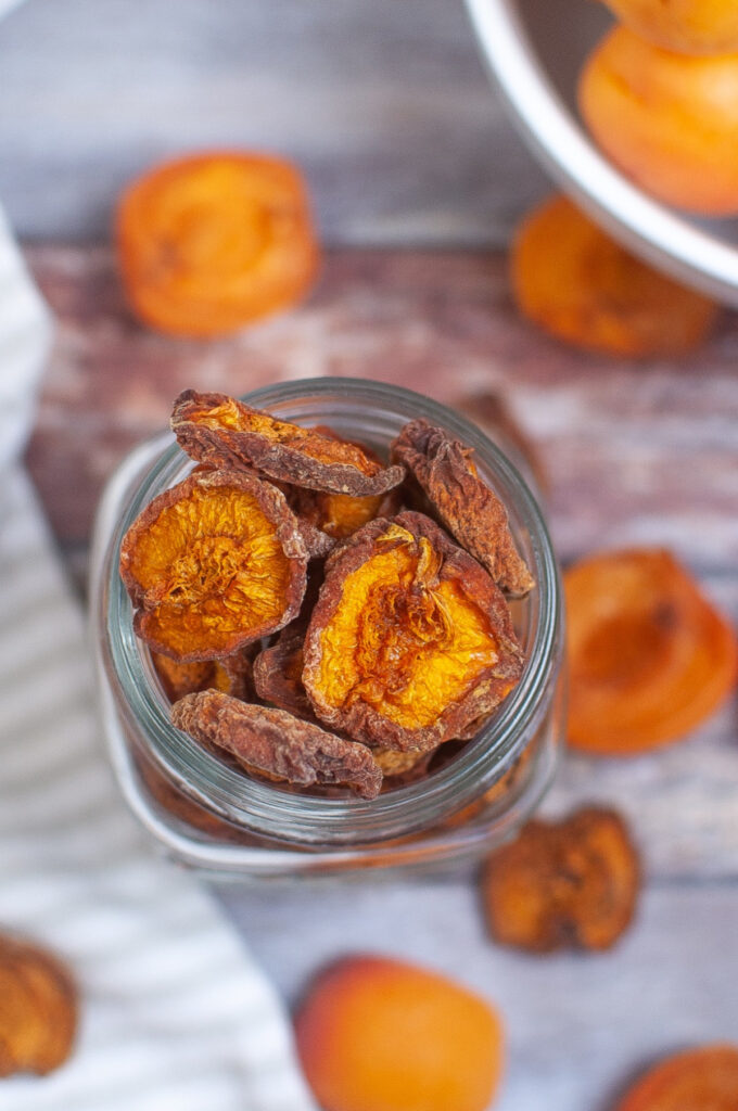 Tope view of dried apricots in a clear jar.