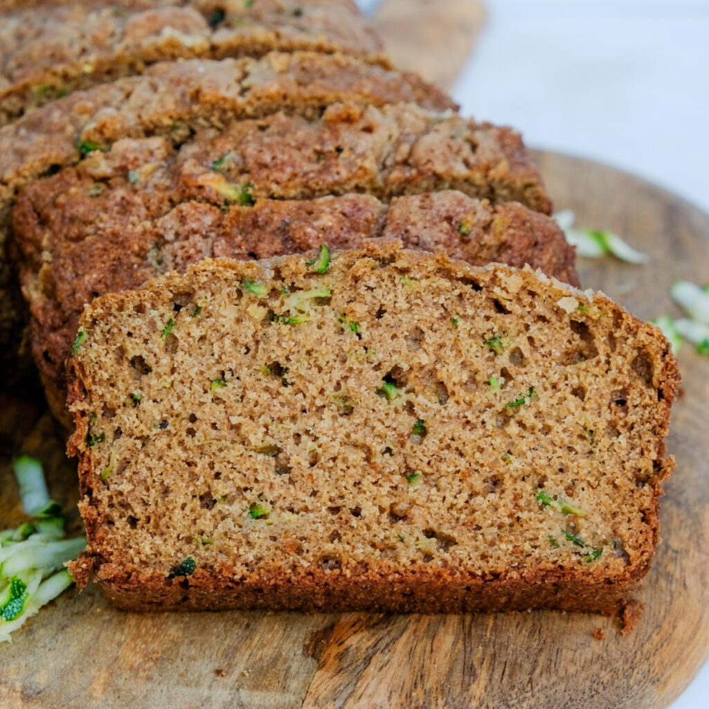 Low-Sugar homemade zucchini bread sliced on a cutting board.