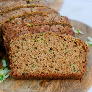 Low-Sugar homemade zucchini bread sliced on a cutting board.