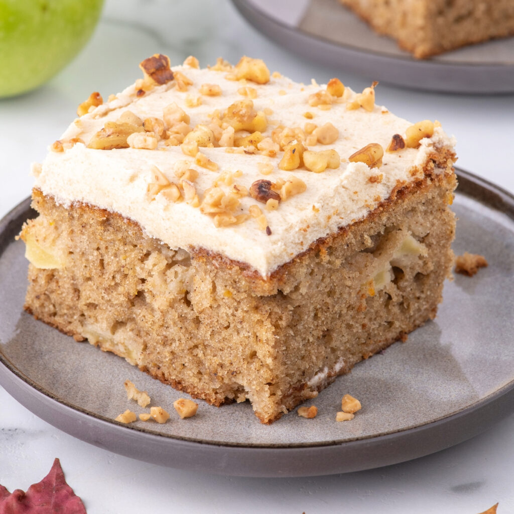 A slice of apple spice cake on a gray serving plate.