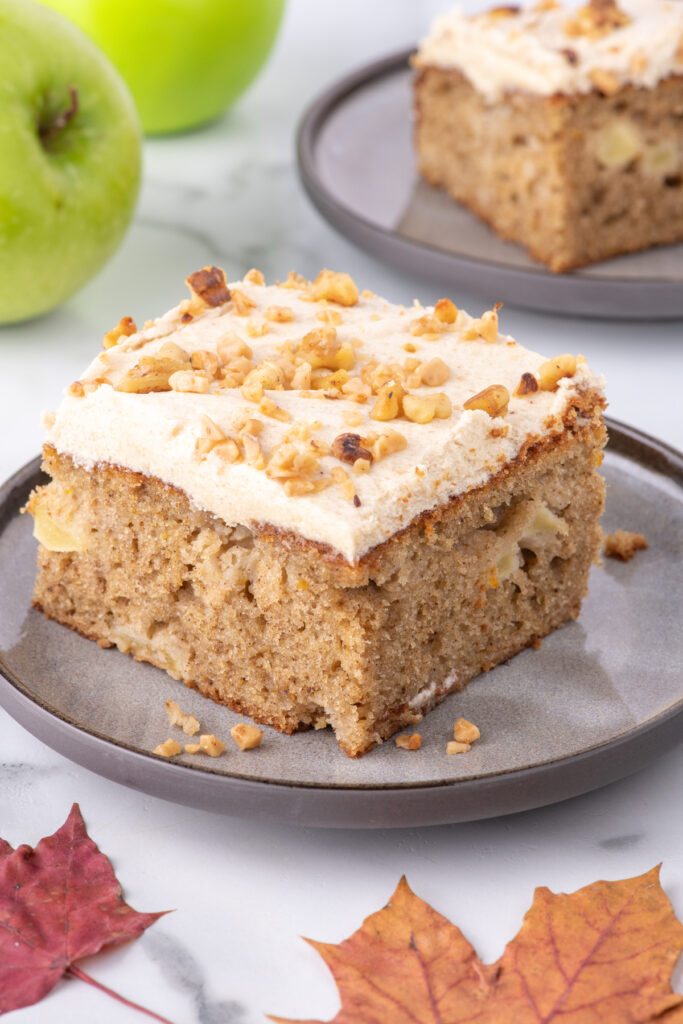 A slice of apple spice cake on a gray plate.