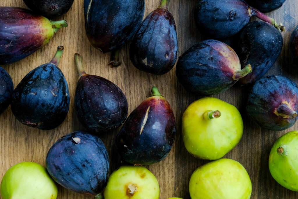 Fresh black and green figs on a brown table. 