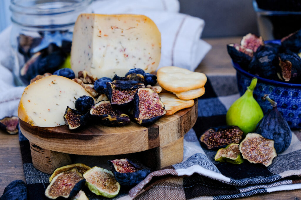 A small cheese board with fruits and nuts. 